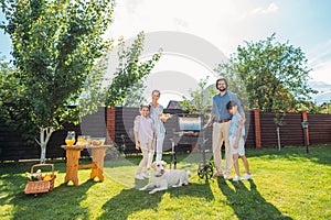 family with dog having barbecue together on backyard