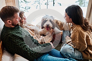 Family With Dog Spending Winter Day At Home