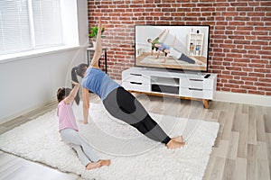 Family Doing Online Fitness Workout Near Television