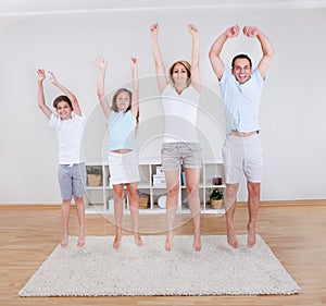 Family Doing Stretching Exercises On The Carpet