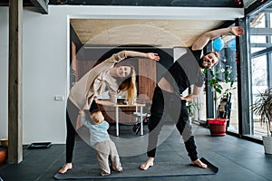Parents doing side tilts while their infant child seeking attention photo