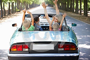 Family driving along in a sports car