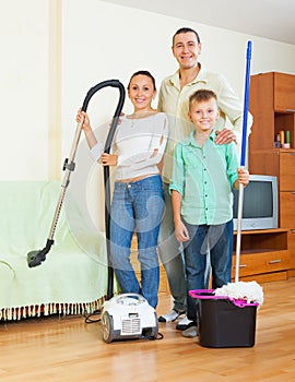 Family dusting with vacuum cleaner