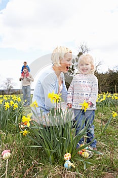 Family On Easter Egg Hunt In Daffodil Field