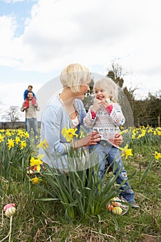 Family On Easter Egg Hunt In Daffodil Field