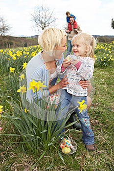 Family On Easter Egg Hunt In Daffodil Field