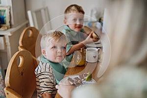 Family eating breakfast together in home kitchen. Healthy breakfast or snack before preschool, school and work.