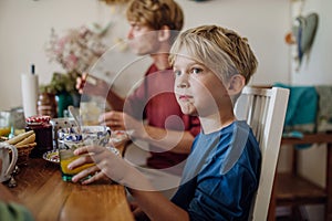 Family eating breakfast together in home kitchen. Healthy breakfast or snack before school and work.