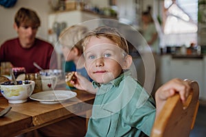 Family eating breakfast together in home kitchen. Healthy breakfast or snack before school and work.