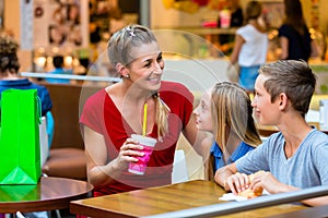 Family eating and drinking in cafe at shopping mall