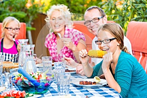 Family at eating in garden barbecue