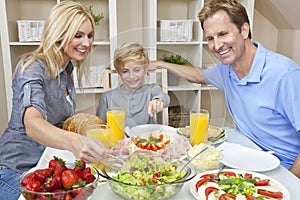 Family Eating Healthy Food & Salad At Dining Table photo