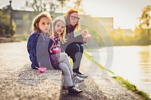 Family eating ice cream, sitting on banks of river Ljubljanica. photo