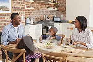 Family Eating Meal In Open Plan Kitchen Together