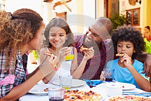 Family Eating Meal At Outdoor Restaurant Together