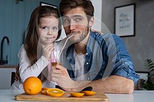 Family, eating and people concept - happy father and daughter having breakfast at home
