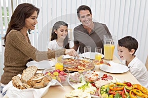 Rodina jíst velký kruhový plát světlého těsta salát na stravování stůl 
