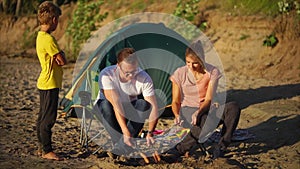 Family eating roasted sausages on holidays in the countryside