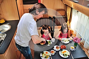 Family eating together in RV interior, travel in motorhome camper, caravan on vacation with kids
