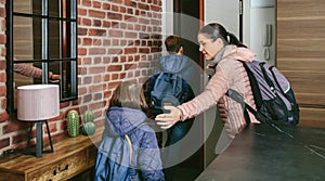 Family with emergency backpacks leaving their front door quickly