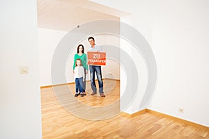 Family In Empty Apartment, Holding `zu Verkaufen` Sign photo