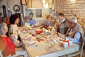 Family enjoy on Christmas dinner and exchange present together