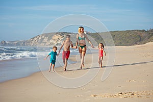 Family enjoy leisure run along sandy shoreline with waves crash