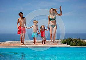 Family enjoy pool time by the sea jump and laugh on vacations