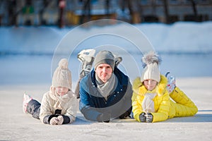 Family enjoy wintersport on ice-rink outdoors