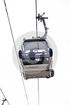 A family enjoying aerial views inside a Vilanova de Gaia cable car gondola suspended on the hanging steel cables under a cloudy photo