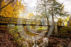 Family Enjoying Autumn Colors on a Park Bridge