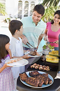 Family Enjoying A Barbeque