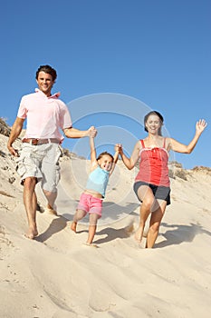 Family Enjoying Beach Holiday Running Down Dune