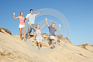 Family Enjoying Beach Holiday Running Down Dune