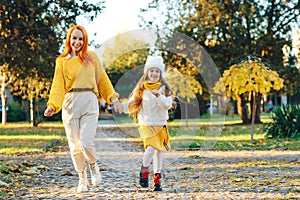 Family enjoying the beautiful autumn nature. Mom and child having fun together. Autumn fashion, lifestyle