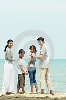 Family enjoying the beautiful view on the beach. Conceptual image