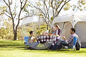 Family Enjoying Camping Holiday In Countryside