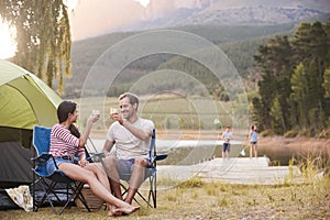 Family Enjoying Camping Vacation By Lake Together