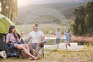 Family Enjoying Camping Vacation By Lake Together