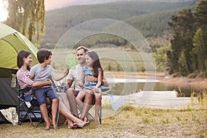 Family Enjoying Camping Vacation By Lake Together