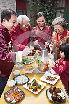 Family enjoying Chinese meal in traditional Chinese clothing