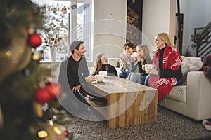 Family Enjoying Hot Drink In Cafe at home close to fireplace