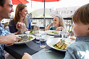 Family Enjoying Meal At Outdoor Restaurant