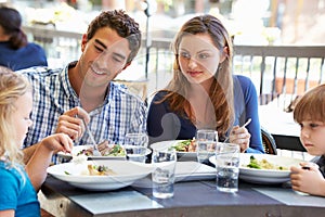 Family Enjoying Meal At Outdoor Restaurant