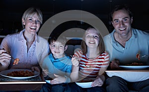 Family Enjoying Meal Whilst Watching TV