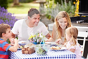 Family Enjoying Outdoor Meal In Garden