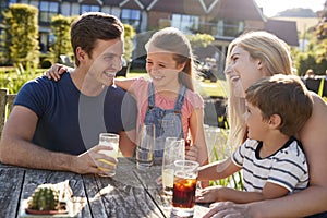 Family Enjoying Outdoor Summer Drink At Pub