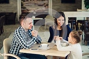 Family Enjoying tea In Cafe Together