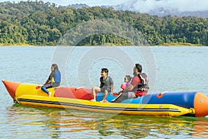 Family enjoying water activities on banana boat at the Kenyir Lake, Terengganu, Malaysia