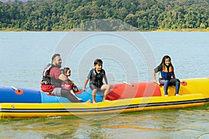 Family enjoying water activities on banana boat at the Kenyir Lake, Terengganu, Malaysia